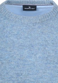 Lichtblauwe gebreide trui met een ronde ribbelkraag. De stof heeft een zachte textuur met een subtiel gemêleerd patroon. Label zichtbaar aan de binnenkant.