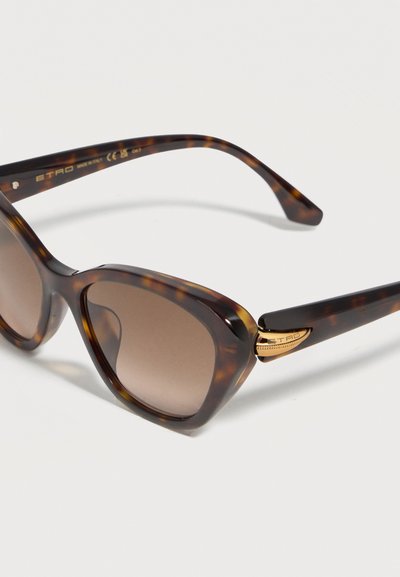 Lunettes de soleil œil de chat en écaille avec verres dégradés marron et détail de charnière dorée gravée "ETRO" sur fond blanc.