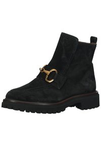 Bota de tornozelo em suede preto com sola grossa preta, apresentando um acabamento de fivela em tom dourado e uma alça na parte de trás para facilitar o calçar e descalçar.