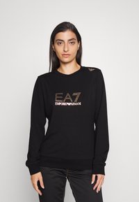 Zwart sweatshirt gemaakt van zacht materiaal, met een ronde hals, lange mouwen en het EA7 Emporio Armani-logo in metallic goud en zilver.