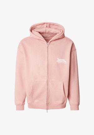 Rosa hettegenser med glidelås laget av mykt stoff, med frontlomme, ribbestrikkede mansjetter og et grafisk trykk på venstre bryst.