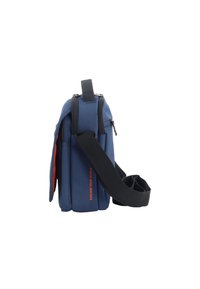 Borsa a tracolla blu con design imbottito, tracolla regolabile, maniglia superiore e testo di accento rosso "ESPLORA IL TUO MONDO" sul lato.