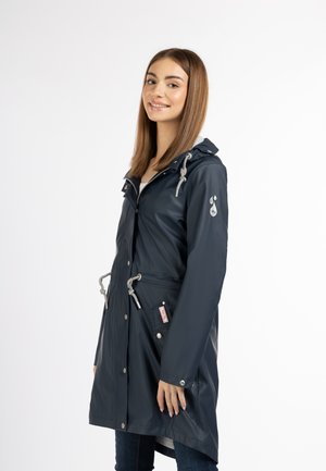 Marineblauwe waterdichte regenjas met een capuchon, trekkoord in de taille, zilveren accenten, drukknoopsluitingen en een logo op de linkermouw.