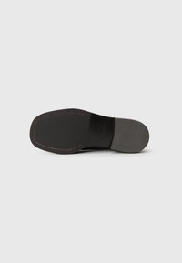 Sole of black formal shoe with leather front, rubber textured heel, visible stitching, and size 39 marking.