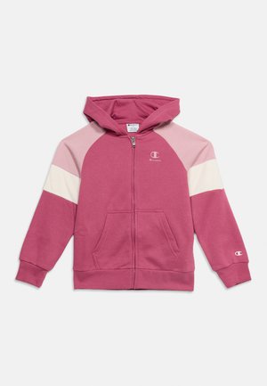 Pink og lyserød hættetrøje med lynlås, forlommer og Champion-logo på bryst og ærme.