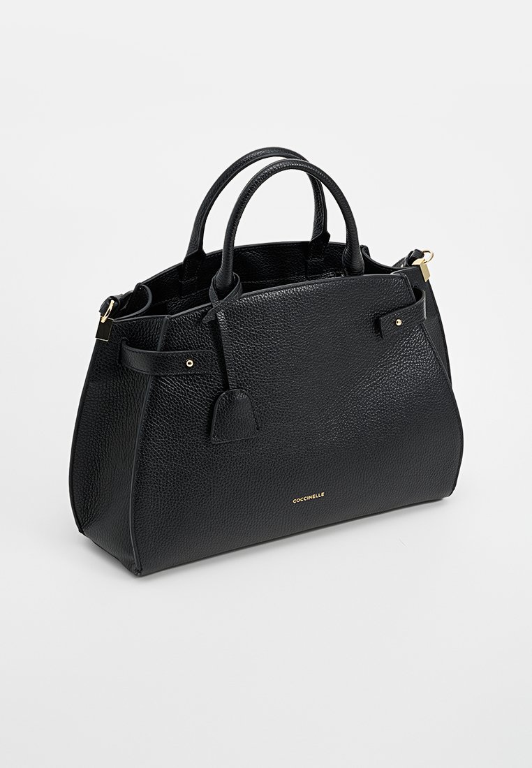 Czarna skórzana torebka o teksturowanym wykończeniu. Posiada dwie rączki, złoty akcent logo oraz odczepianą metkę. Strukturalny design, średni rozmiar.