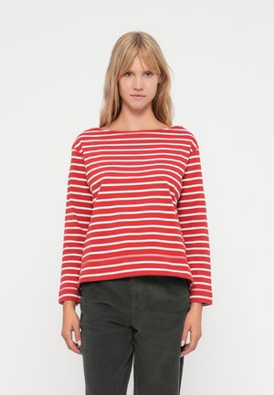 Red long-sleeve top with white horizontal stripes, wide neckline, and loose fit. Paired with dark green corduroy pants.
