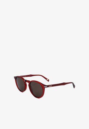 Occhiali da sole con montatura rotonda, lenti scure e aste rosse traslucide, con il marchio "Levi's" sul lato.