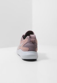 Sneaker con una toma superiore in sintetico viola, dettagli in morbido rosa a contrasto, collare imbottito e suola in gomma bianca. Include un tab sul tallone.