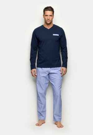 Camiseta azul marino de manga larga con cuello en V y un bolsillo azul combinada con pantalones de pijama estampados en azul claro, confeccionados en suave tela de algodón.