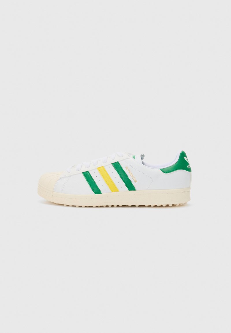 White low-top sneakers with green and yellow stripes, rubber shell toe, and textured cream outsole. Branding on the heel and tongue.