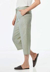 Hellgrüne, Leinenmischung, kurz geschnittene Hose mit einem elastischen Bund und seitlichen Taschen, die eine lockere Passform und glatte Textur aufweist.