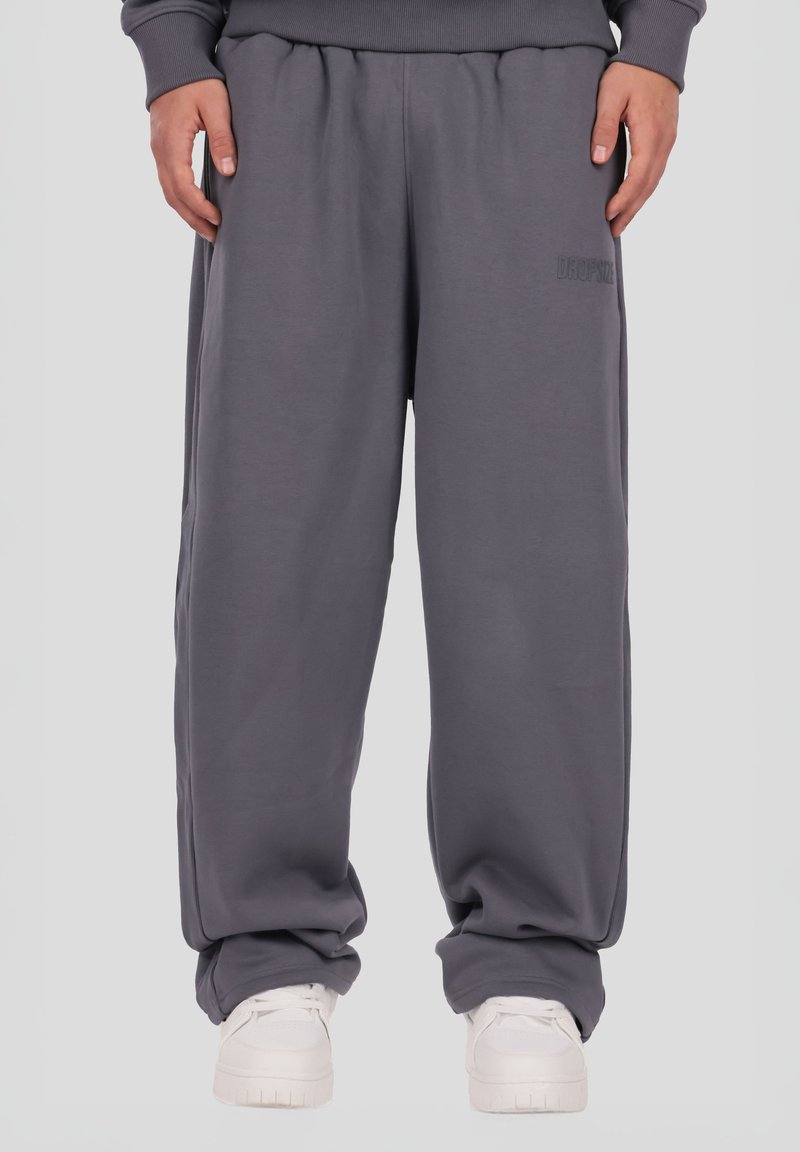 Grå joggingbukser med løs pasform, elastisk taljebånd og sidelommer. Lavet af blødt materiale med diskret branding på låret.