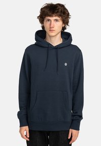 Marineblauwe hoodie van zachte stof, met een voorzak in kangoeroestijl, ribgebreide manchetten en een klein geborduurd logo op de borst.