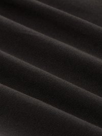 Mjukt svart tyg med fin horisontell ribbad textur och subtila veck som framhäver materialets släta, sammetsliknande yta.