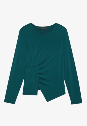 Teal long-sleeve top made of soft fabric. Features a gathered side design and an asymmetrical hemline. Round neckline and fitted silhouette.