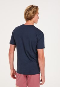 Camiseta de algodón de manga corta en color azul marino, con cuello redondo y dobladillo recto, sin patrones ni acentos visibles.