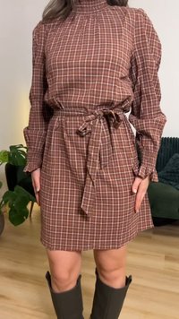 Ruskearuudullinen mekko, jossa korkea kaulus, pitkät hihat ja solmittava vyö vyötäröllä. Yhdistetty harmaisiin polven korkeisiin saappaisiin.