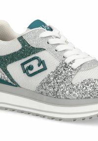 Baskets argentées scintillantes avec tige en mesh blanc, accents bleu sarcelle et lacets blancs. Présentent une surface texturée et une semelle légèrement surélevée.