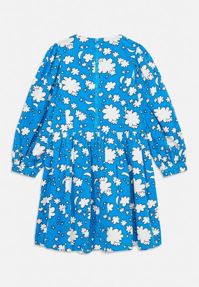 Modré šaty s dlhým rukávom s bielymi motívmi oblakov, mesiaca a hviezd, zošitý pás a zapínanie na gombíky na manžetách, rozložené na bielom pozadí.