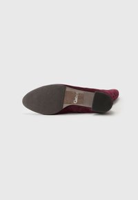 Bordeauxkleurige suede pump met een ronde neus, instapontwerp en een korte, gestructureerde rubberen hak. Heeft een Gabor-logo op de binnenzool.