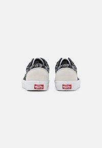 Černé plátěné tenisky s šedými semišovými doplňky a bílými gumovými podešvemi. Na patě jsou červené štítky s logem. Minimalistický design.