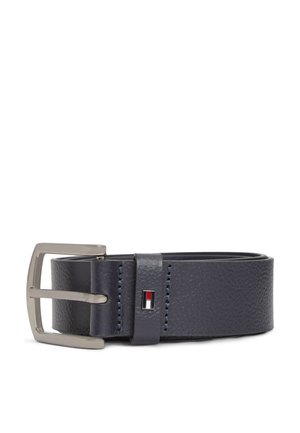 Ceinture en cuir texturé bleu foncé roulée avec une boucle en métal rectangulaire argentée et un petit détail de logo rouge, blanc et noir sur la boucle de ceinture.