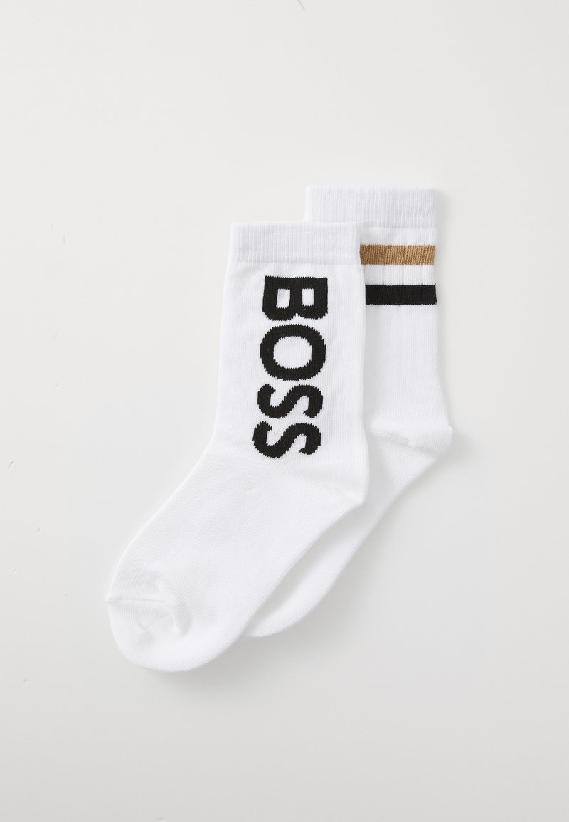 Calcetines blancos de algodón con el texto "BOSS" en negro y un patrón de rayas contrastantes en negro y dorado en uno de los calcetines.