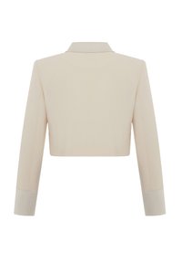Veste beige coupée avec un col ajusté, des manches longues et des poignets contrastants. Texture lisse avec un minimum de détails de couture à l'arrière.