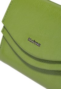 Portefeuille en cuir vert avec un design plié, présentant une texture lisse et un logo "MAÎTRE" en argent. Forme compacte et fonctionnelle.