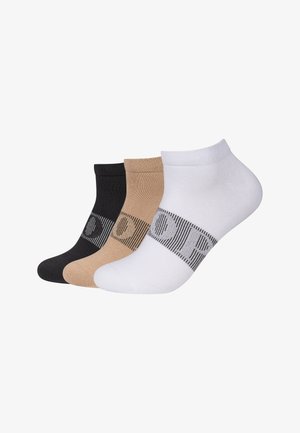 Drie paar enkelsokken in zwart, beige en wit, elk met een horizontale zwarte streep met een cirkelpatroon over de wreef.