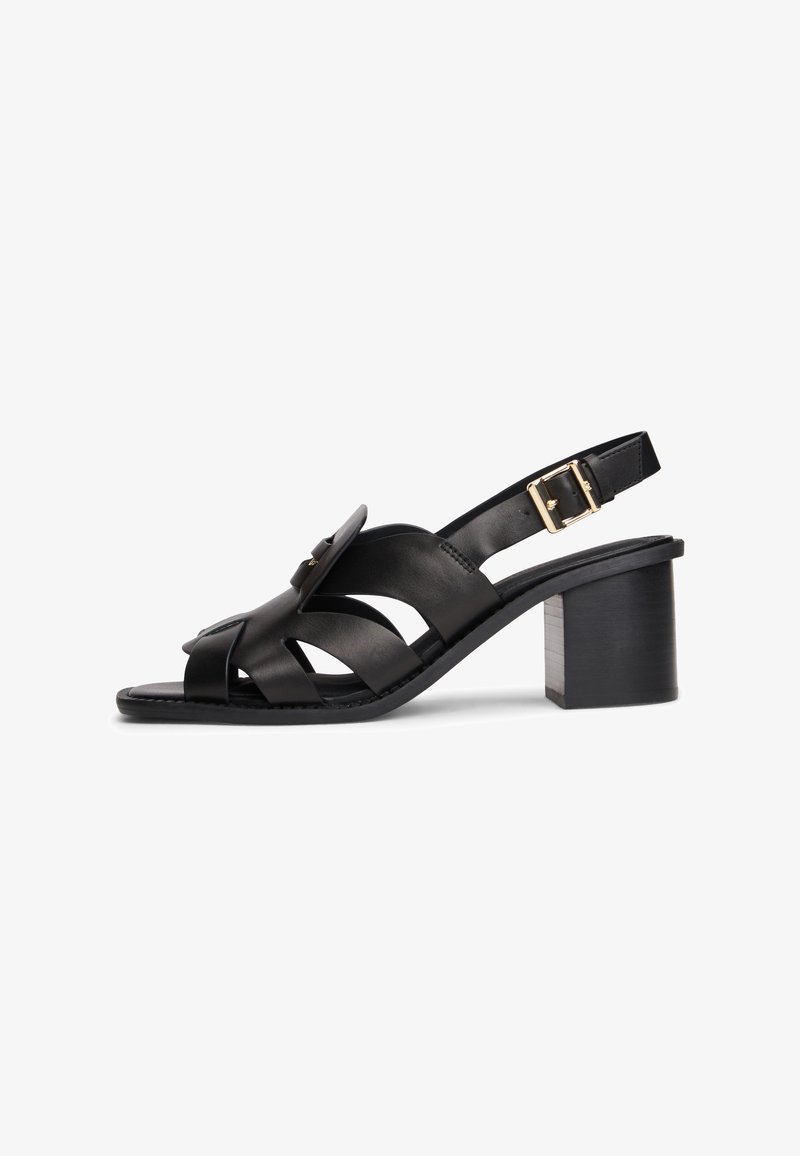Black leather open-toe sandal with block heel, crisscross straps, a buckle closure on the ankle strap, and decorative gold-tone details.
