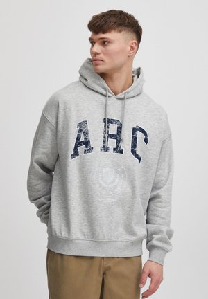 Grå hættebluse lavet af blødt materiale, med et stort slidt "ARC" print i marineblå og et rundt logo grafisk nær taljen.
