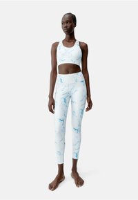 Sport-bh en legging set met marmerpatroon in lichtblauw en wit. Gemaakt van gladde, rekbare stof. Kenmerkt zich door een hoge tailleband en racerback ontwerp.