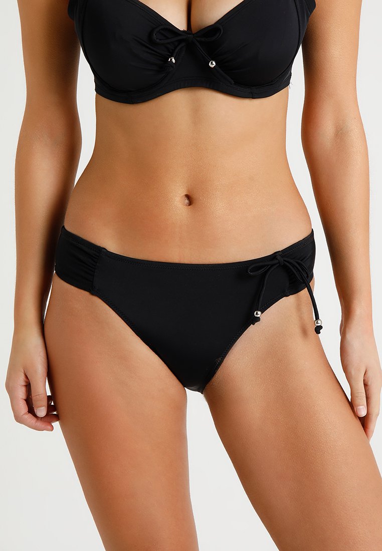 Top de bikini preto com um laço frontal e acabamentos em prateado; parte de baixo correspondente com laços laterais. Feito de material suave e elástico.