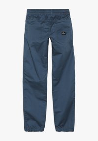 Pantalones azules ligeros con cintura elástica, dos bolsillos traseros y costuras en contraste. El material parece suave y tiene un ajuste holgado.