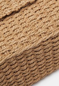 Cesto portaoggetti intrecciato di colore naturale beige, realizzato con fibre strutturate. Presenta una forma rettangolare con struttura robusta e coperchio chiuso.