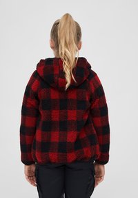 Röd och svart rutigt fleecejacka med huva, med en strukturerad utsida och elastiska manschetter, sedd bakifrån.