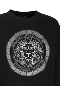 Schwarzes Sweatshirt mit einem runden weißen Grafikelement, das einen Löwen zeigt, umgeben von einem dekorativen Rand und dem Text "MILANO 1969 ITALIA."