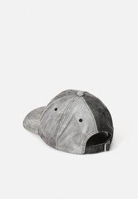 Casquette de baseball en denim gris avec une finition texturée, présentant des sections contrastées claires et foncées, six trous de ventilation et une sangle ajustable.