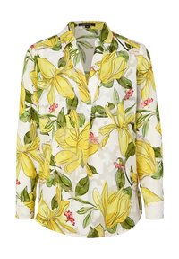 Blouse fleurie à manches longues, présentant un motif floral jaune et vert sur fond blanc. Fabriquée en tissu léger et transparent.