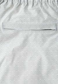 Lightweight fabric shorts with a geometric grey pattern on a white background; features an elastic waistband and a back pocket.
