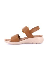 Sandalo in pelle marrone con due ampie cinghie, soletta imbottita e suola flessibile color crema con scanalature per la trazione.