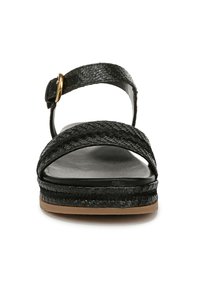 Sandali neri intrecciati con cinturino alla caviglia e dettagli dorati, suola piatta, e materiale nero testurizzato. Presentano un design della piattaforma liscio.