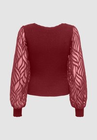 Maglione color bordeaux con corpo a coste e maniche trasparenti e strutturate con motivo a foglia. Polsini aderenti e scollo rotondo.
