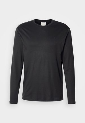 T-shirt noir à manches longues et col rond de Calvin Klein avec un petit logo CK sur la poitrine gauche, présenté sur un fond blanc uni.