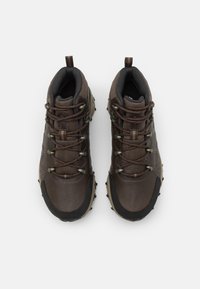 Brown hiking boots with textured leather and mesh upper, rubber outsole with lugs, and metal eyelets for laces. Includes pull tab at heel.