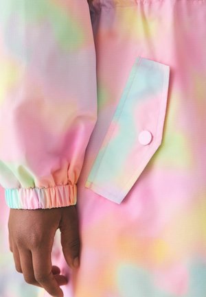Windbreaker in Pastellfarben mit glatter, irisierender Textur, elastischen Bündchen und einer Seitentasche mit rundem Knopfakzent.