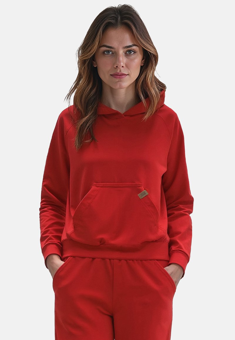 Rød hættetrøje lavet af blødt stof, med en frontlomme og en snoretrækshætte. Lange ærmer med ribkant. Simpelt, afslappet design.