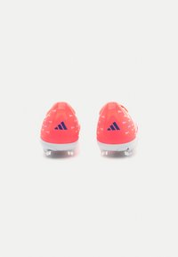 Botas de fútbol de color rosa brillante con una parte superior texturizada, que presenta patrones angulares blancos y un logo azul. Diseñadas con un material sintético ligero.